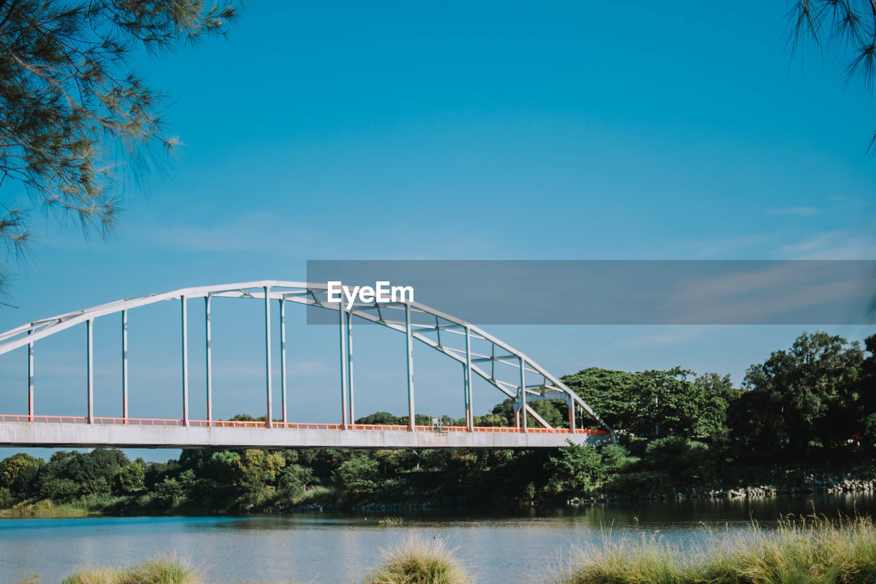 BRIDGE OVER RIVER AGAINST BLUE SKY