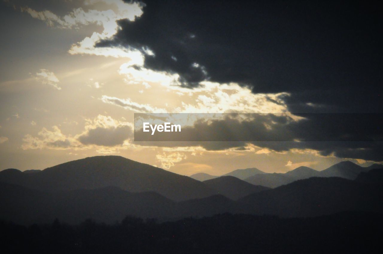 Scenic view of mountains against cloudy sky