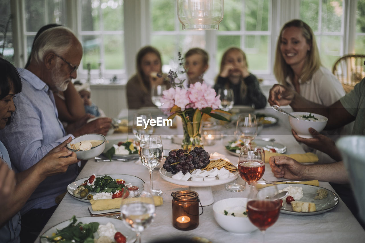 Multi-generation family enjoying dinner on table during party at home