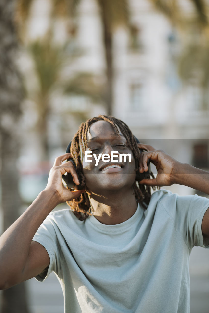 Happy man listening music through headphones