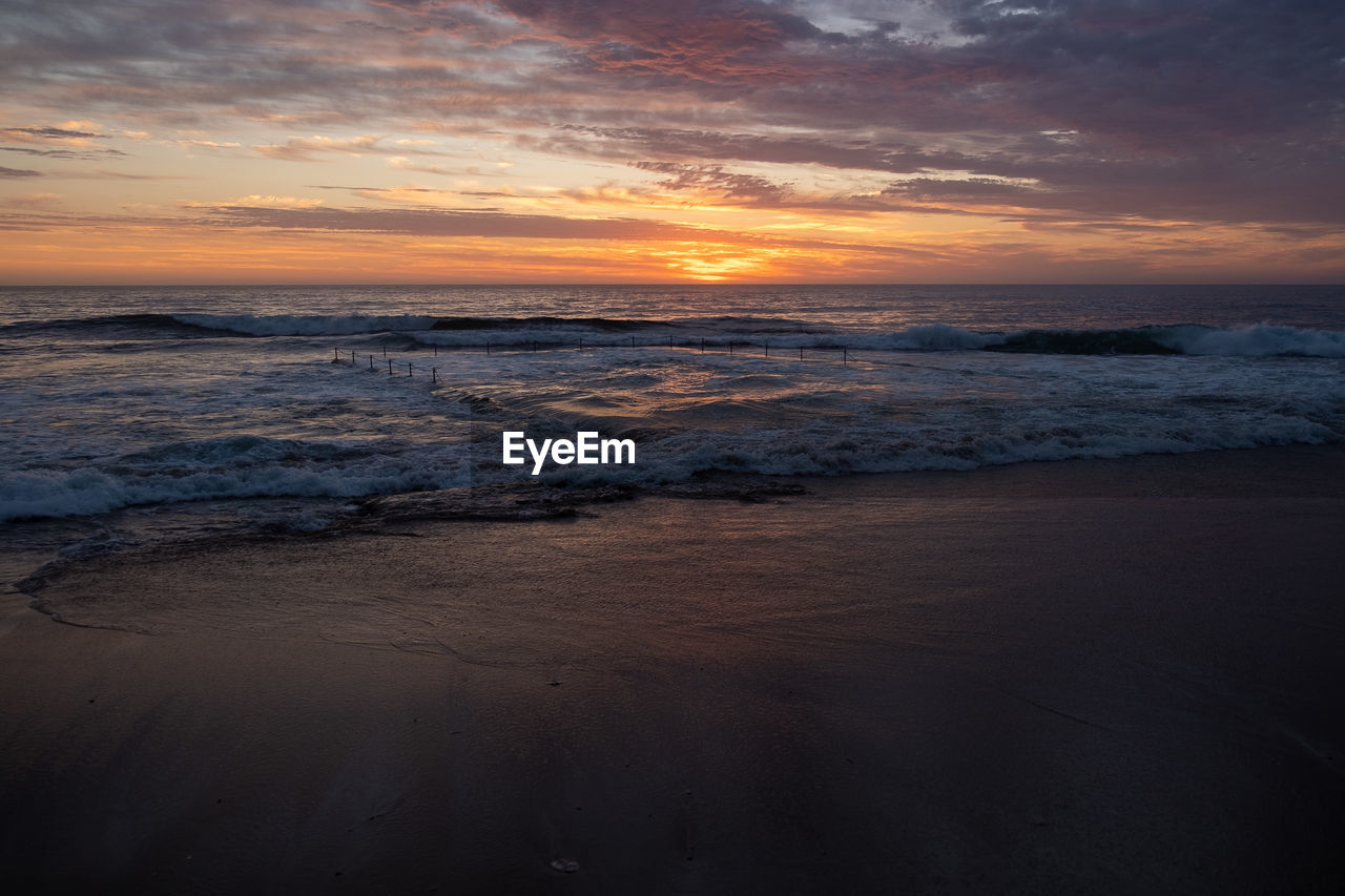 SCENIC VIEW OF BEACH DURING SUNSET