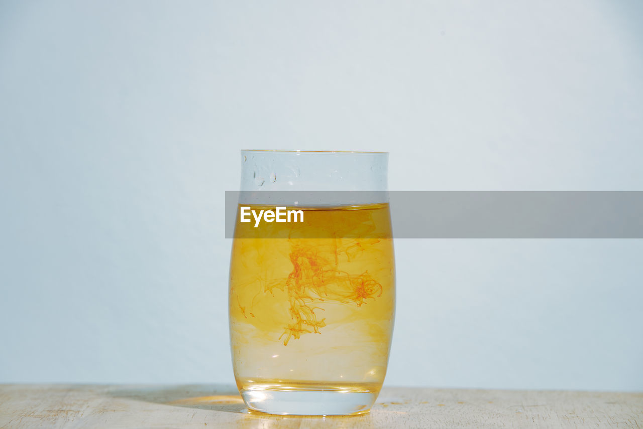 refreshment, drink, drinking glass, food and drink, household equipment, glass, yellow, studio shot, alcohol, beer glass, indoors, beer, distilled beverage, alcoholic beverage, freshness, no people, still life, gray background, table, single object, close-up, cold temperature, copy space, water