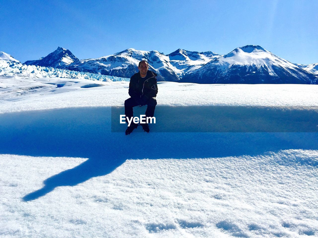 Man sitting on snowy field at glaciar perito moreno