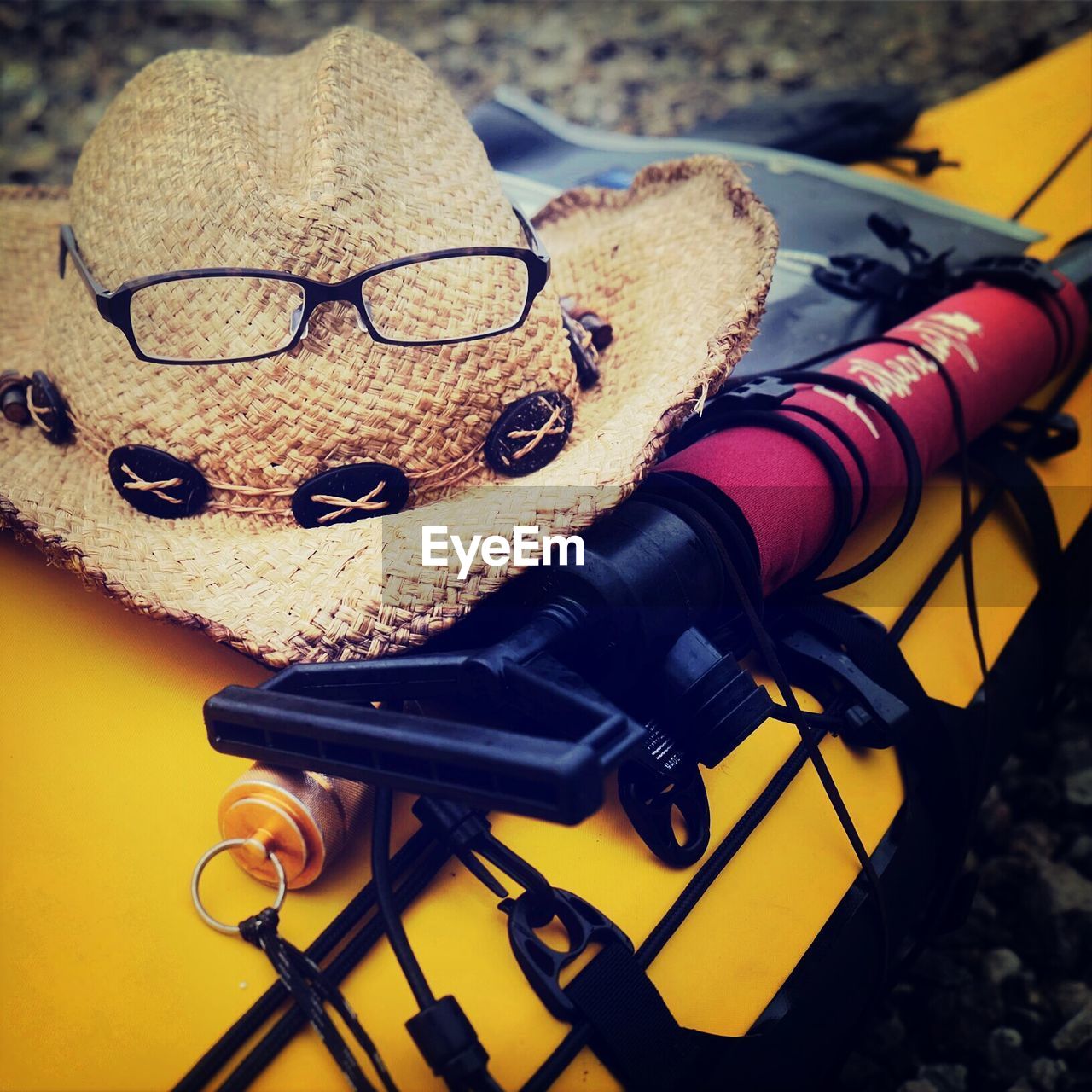 Cropped image of yellow kayak with hat and eyeglasses