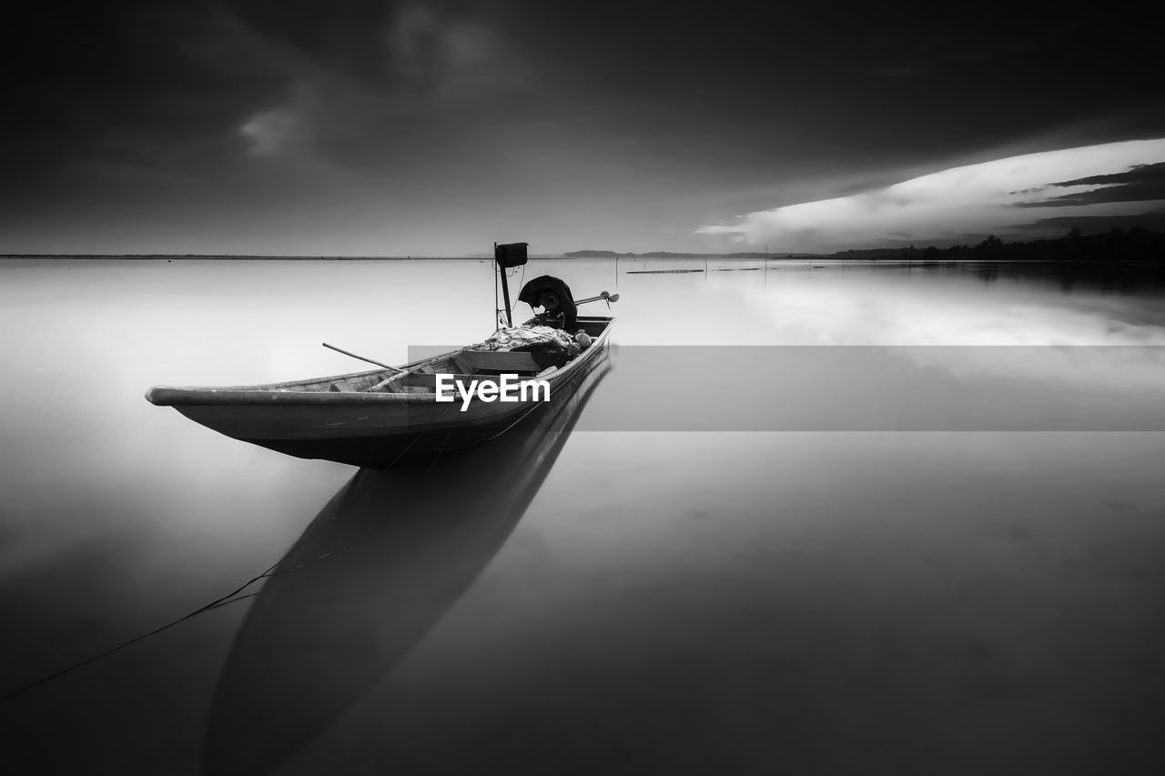 REFLECTION OF MAN ON BOAT IN WATER