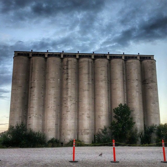 LOW ANGLE VIEW OF COLUMNS AGAINST CLOUDY SKY