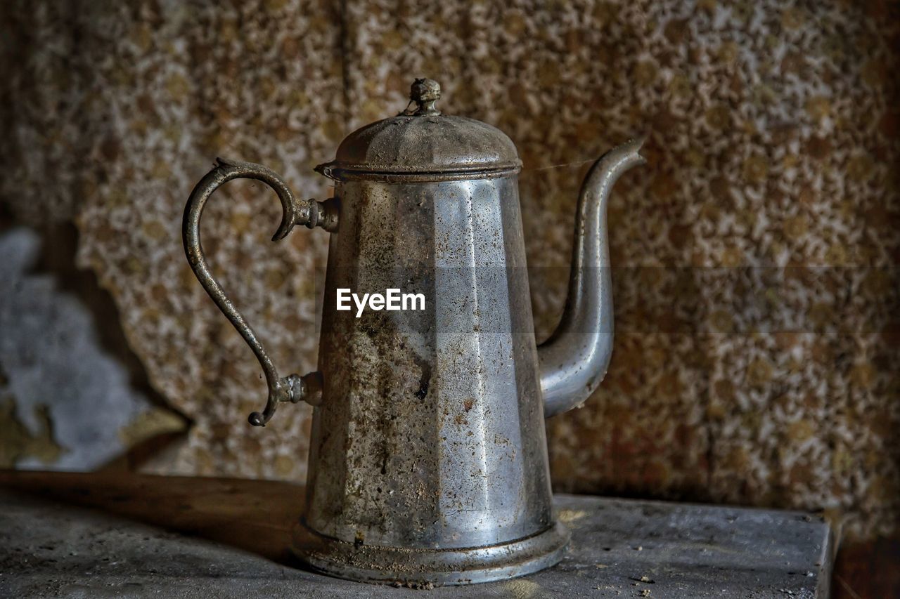 Old metallic teapot on table