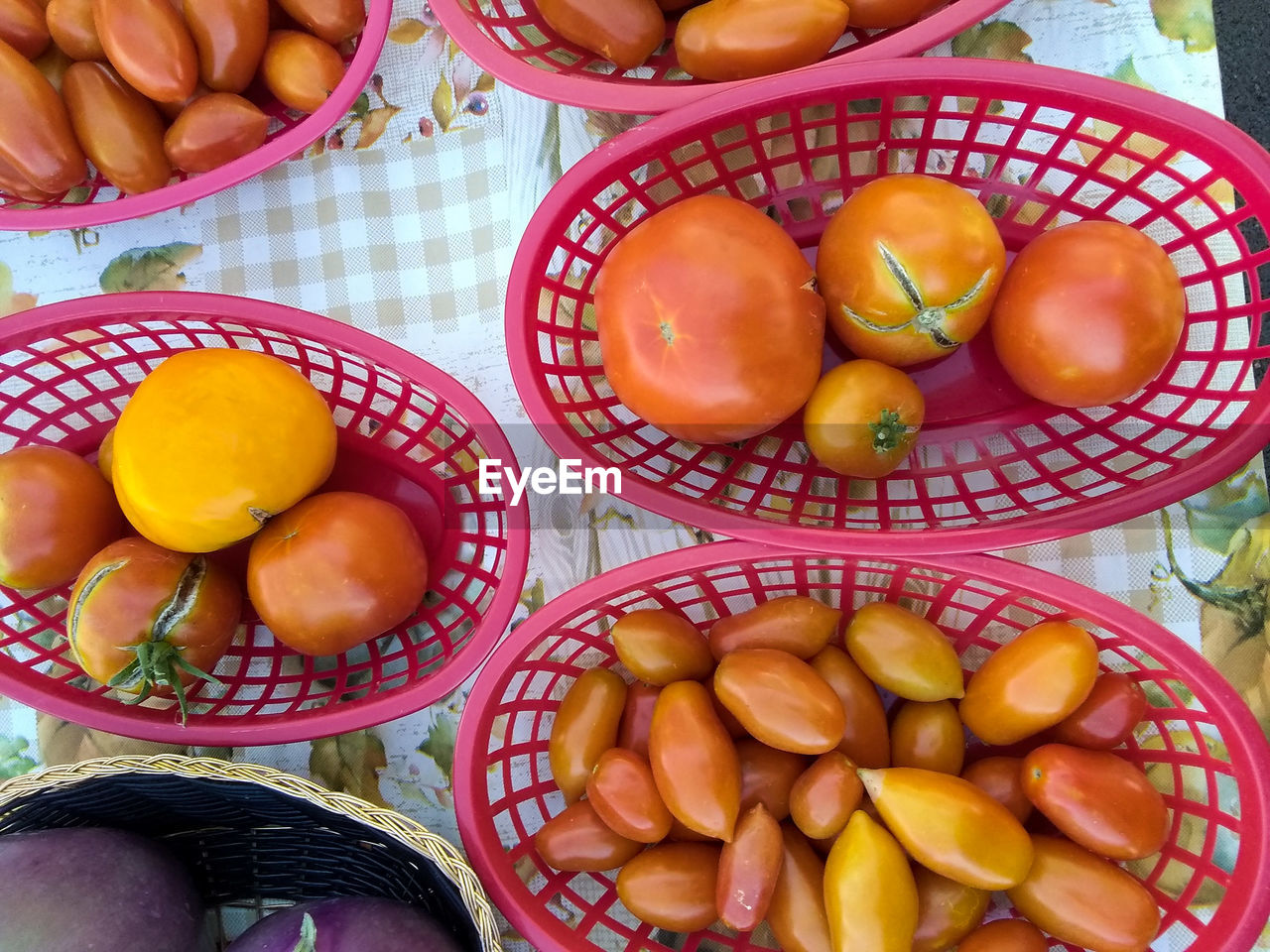 Above view of baskets of vegetables on table in vendor's booth at local farmer's market