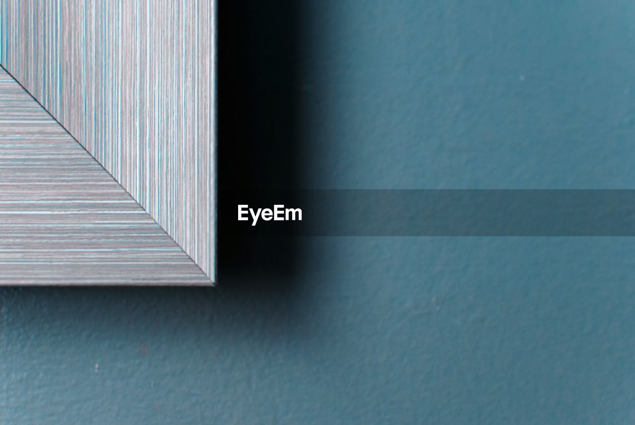 Cropped image of picture frame against blue wall