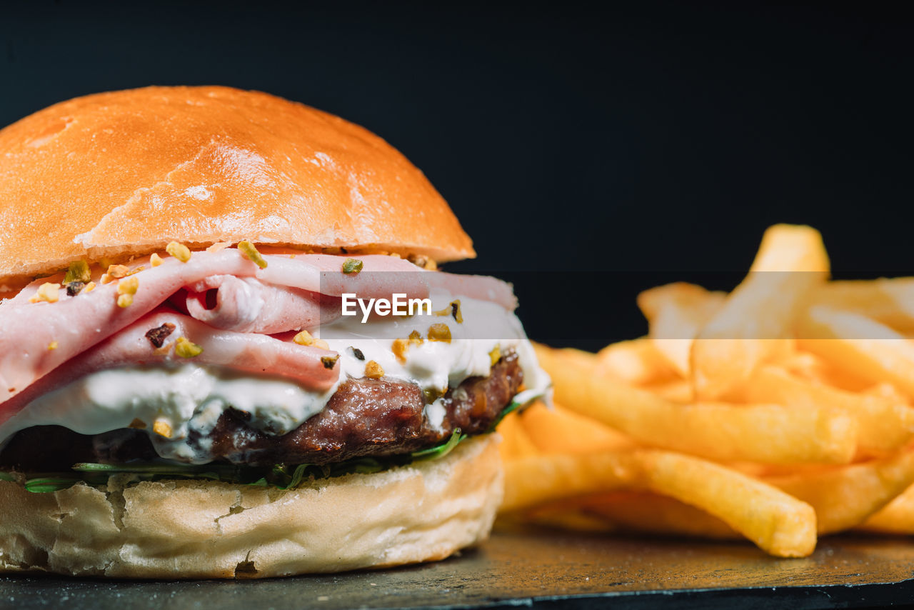 CLOSE-UP OF BURGER ON BARBECUE GRILL