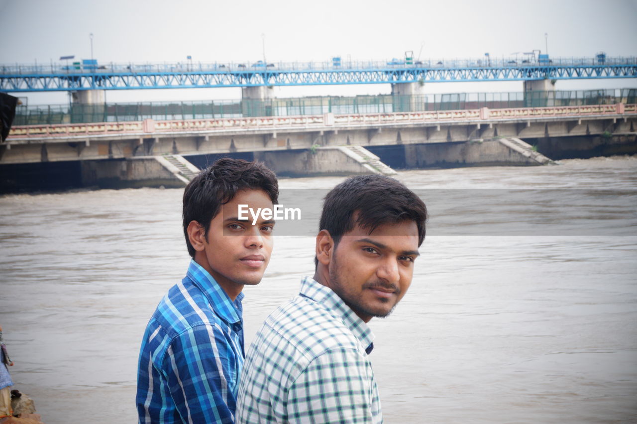 Portrait of male friends by river