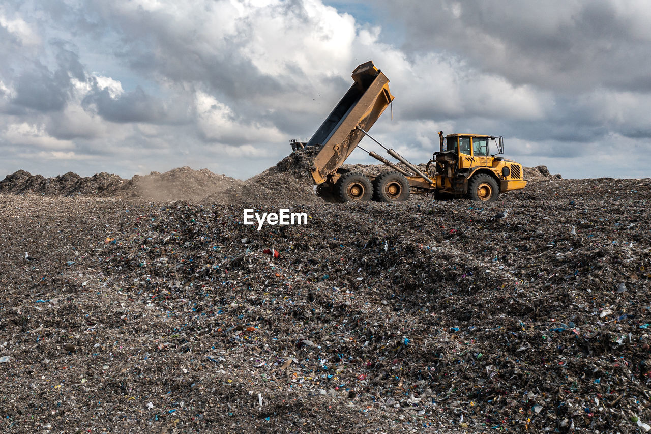 A dumper truck on a large waste management landfill site dumping rubbish in an environmental issue 