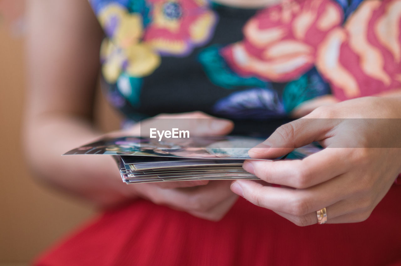 Midsection of woman holding photographs