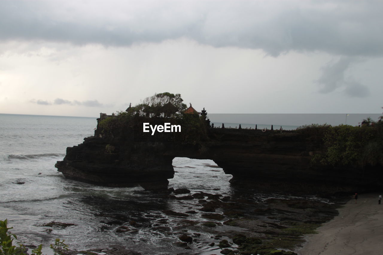 ROCK FORMATIONS ON SHORE AGAINST SKY