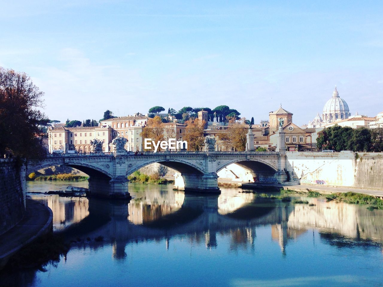 Bridge over river in city against sky