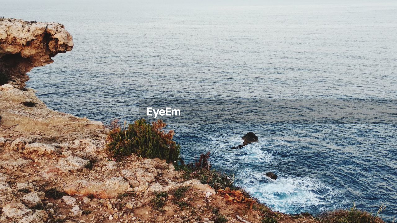 High angle view of rocks on sea against sky