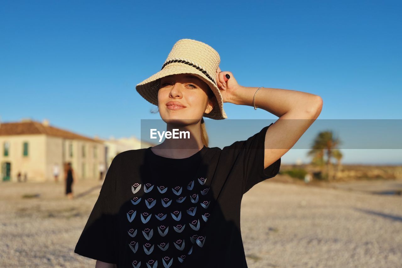 Portrait of young woman standing at beach