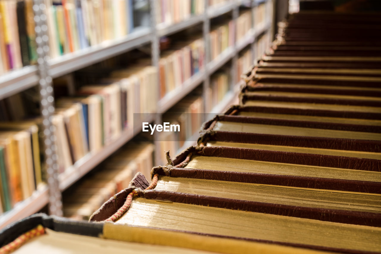 CLOSE-UP OF BOOKS ON SHELF AT LIBRARY