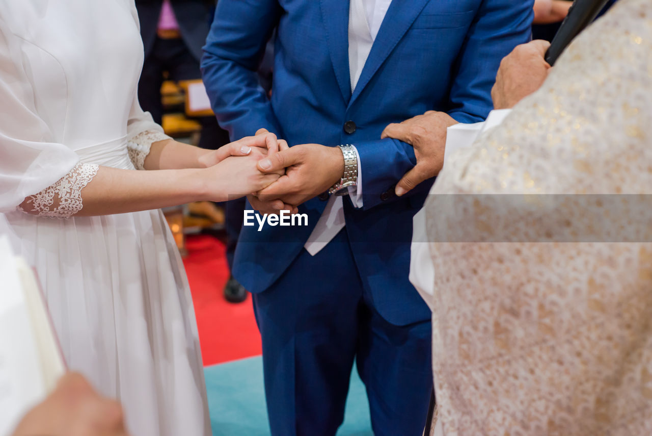 Close-up of wedding couple holding hands