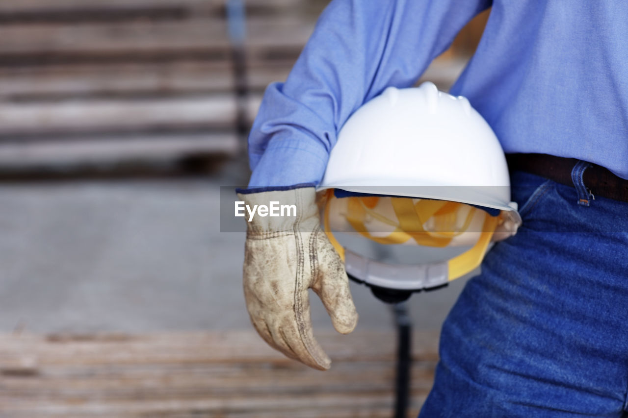 Close up of a male construction foreman holding a hard hat