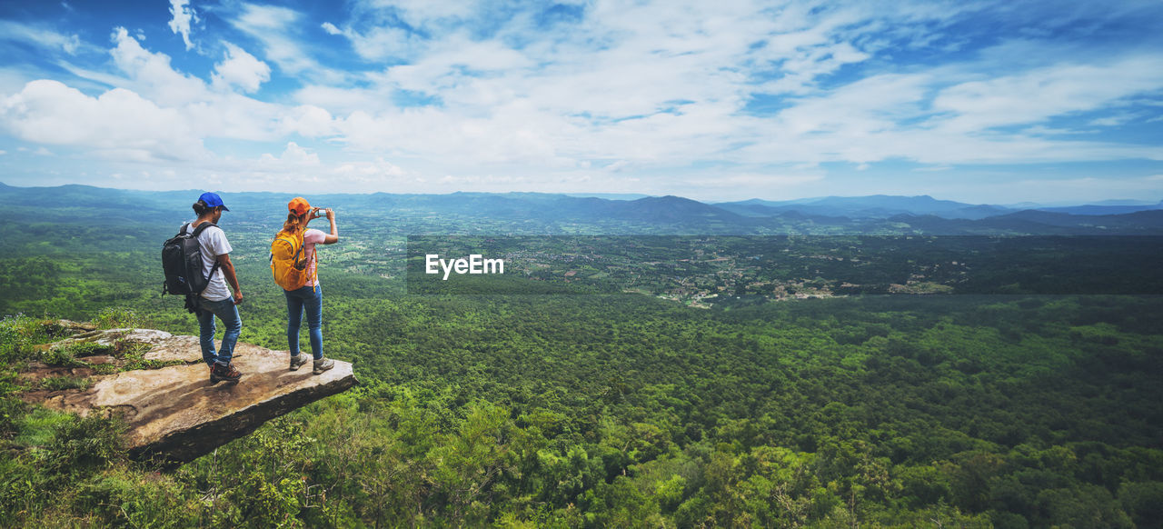 rear view of man standing on mountain against sky