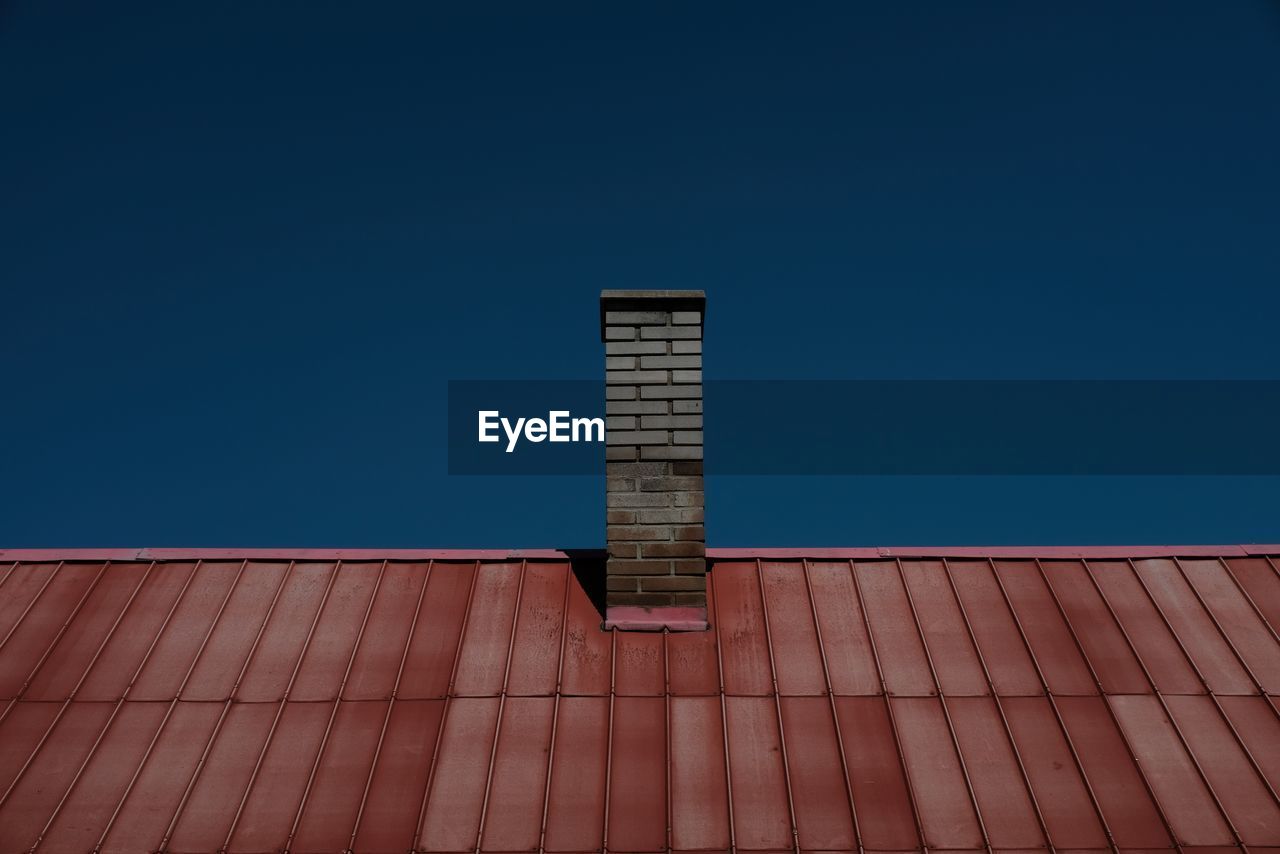 LOW ANGLE VIEW OF ROOF OF BUILDING AGAINST BLUE SKY