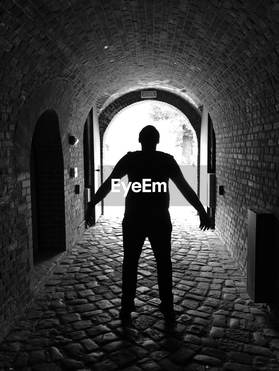 MAN STANDING IN TUNNEL