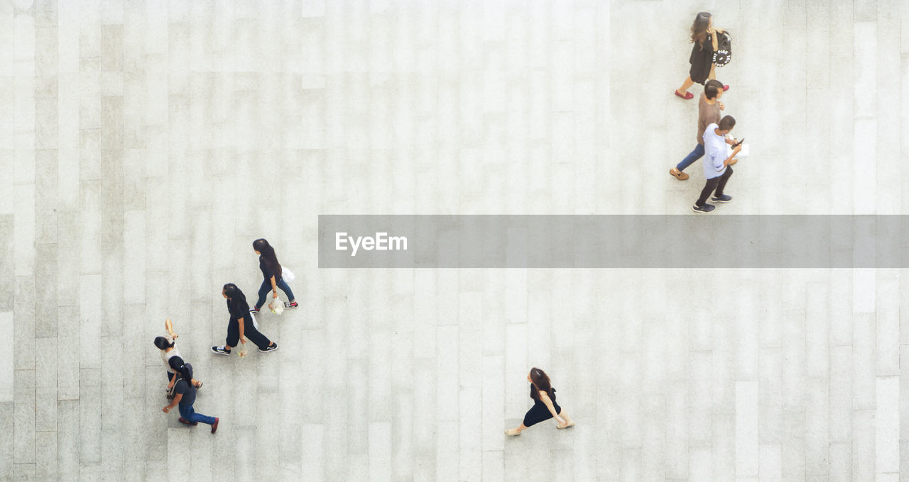 HIGH ANGLE VIEW OF PEOPLE WALKING ON FLOOR IN BACKGROUND