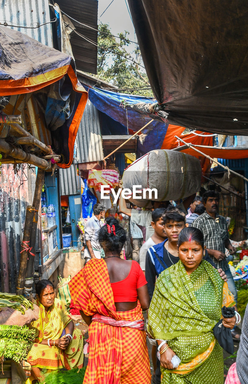 GROUP OF PEOPLE AT MARKET STALL