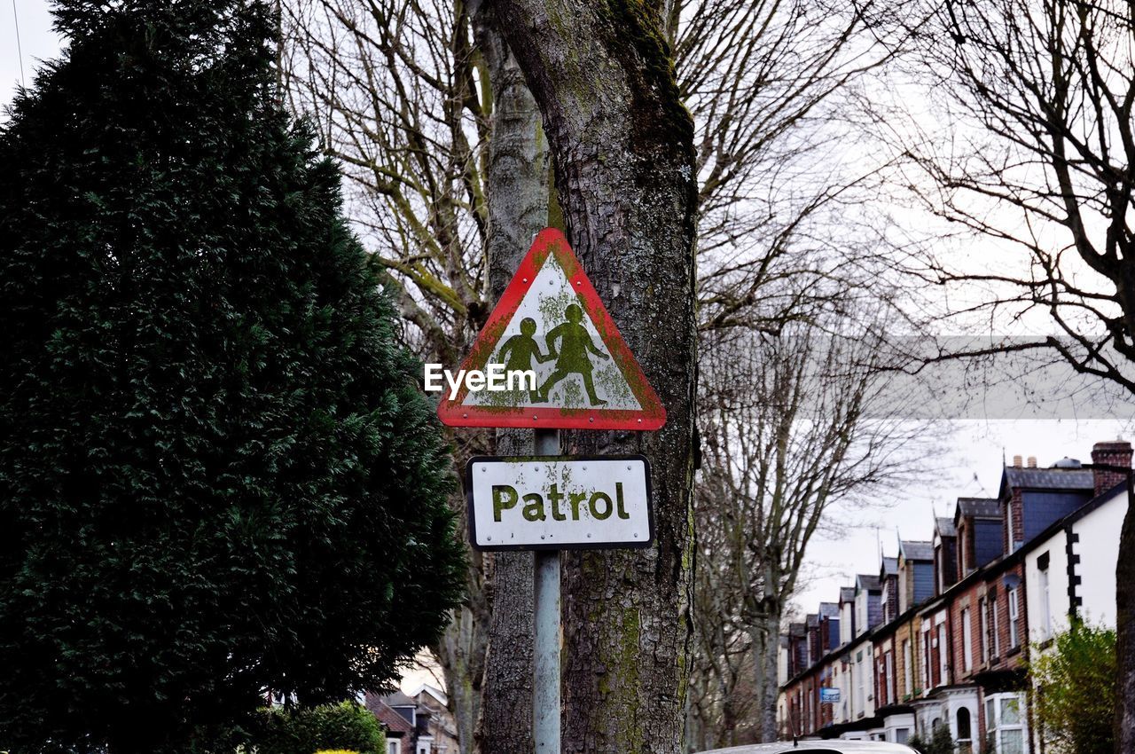 Low angle view of information sign against tree