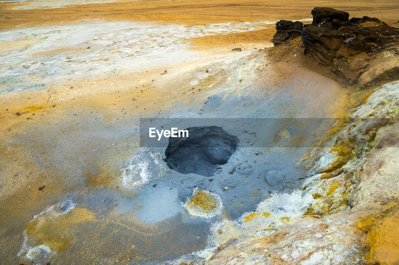 HIGH ANGLE VIEW OF WET ROCK ON SHORE