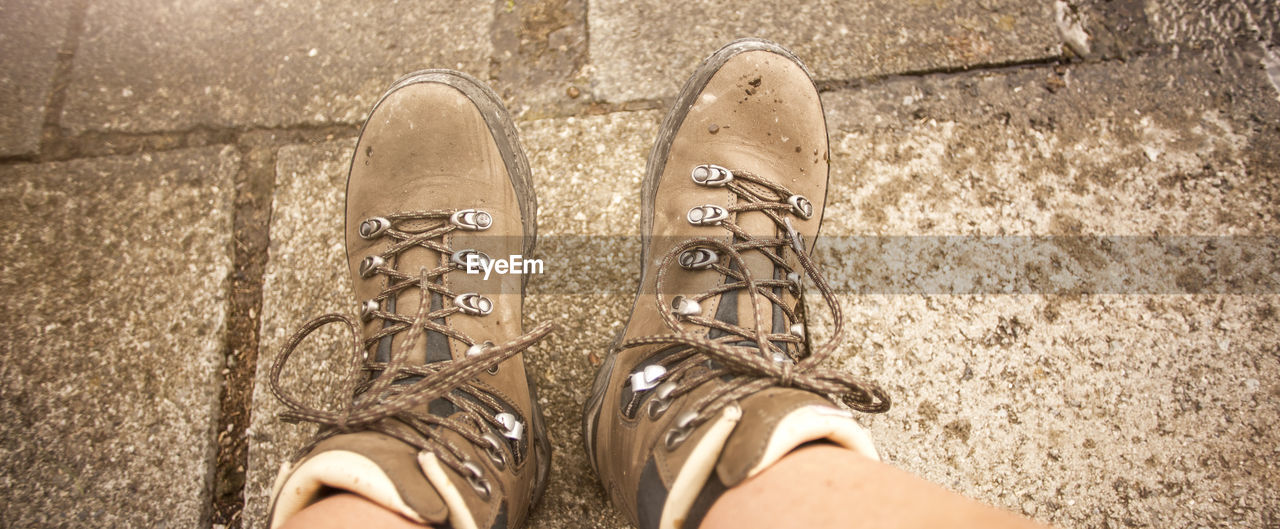 shoe, low section, human leg, personal perspective, one person, standing, lifestyles, limb, spring, human limb, black, footwear, high angle view, white, directly above, human foot, leisure activity, day, adult, outdoors, women, canvas shoe, footpath, sandal, nature, men, hand