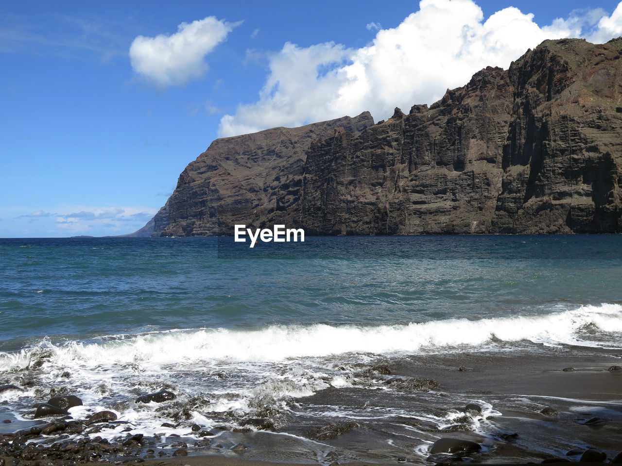 Scenic view of sea and mountains against sky