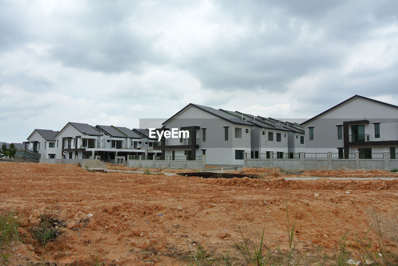 Houses on field against sky