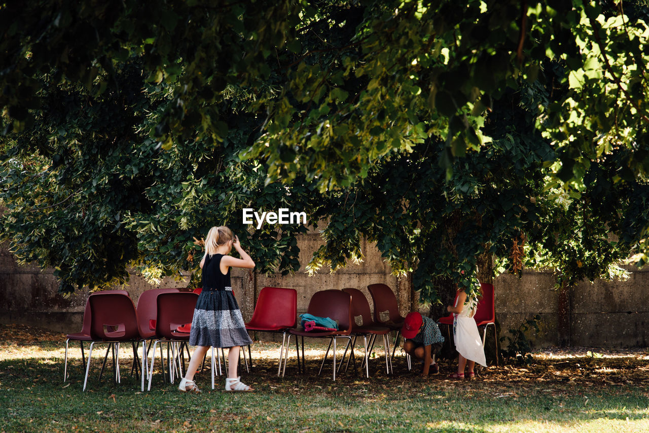 Friends playing by chairs at park