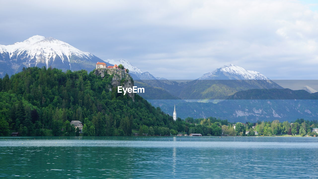 Scenic view of lake by mountains against sky