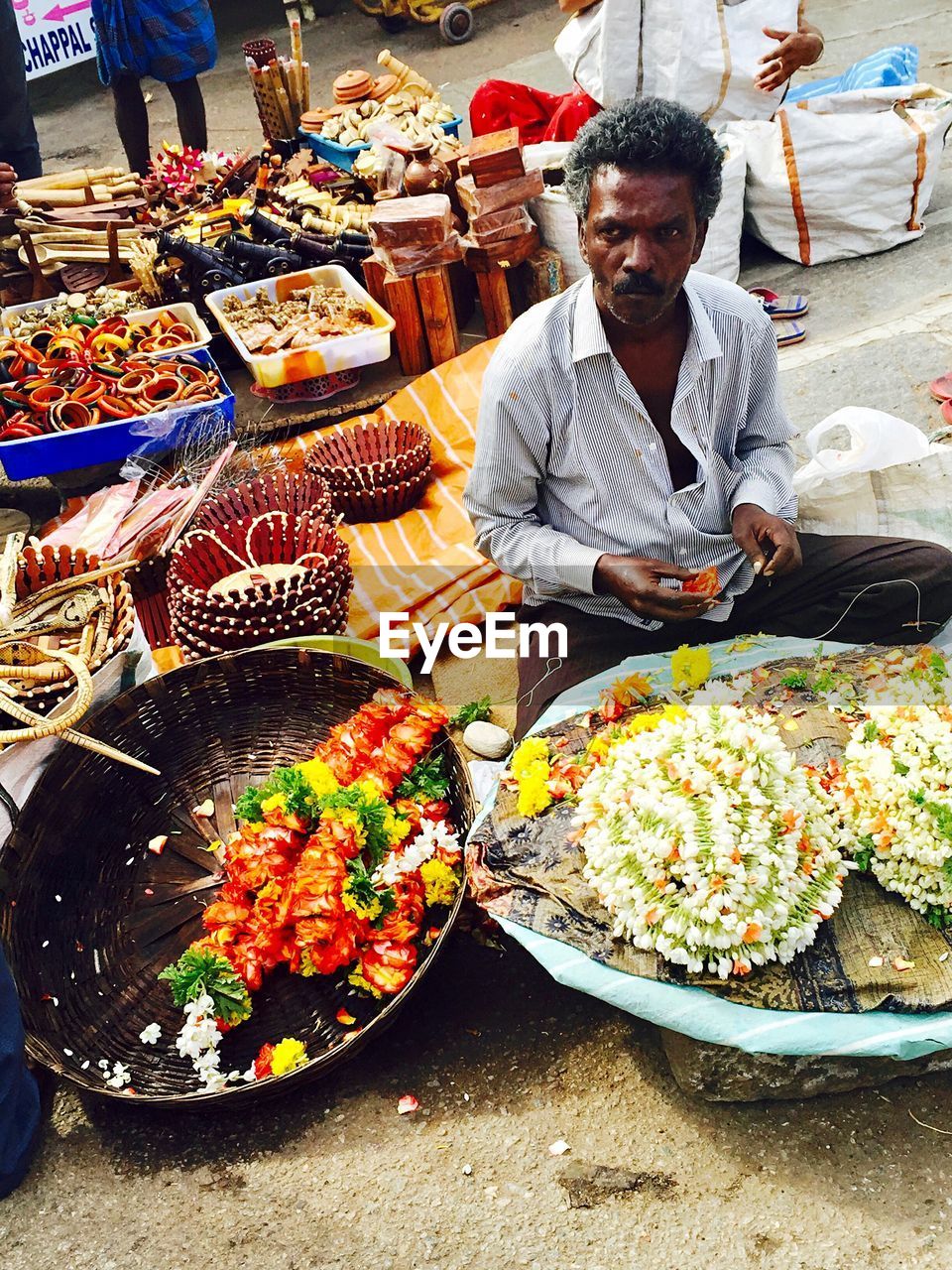 FULL LENGTH OF MAN HOLDING VEGETABLES AT MARKET STALL