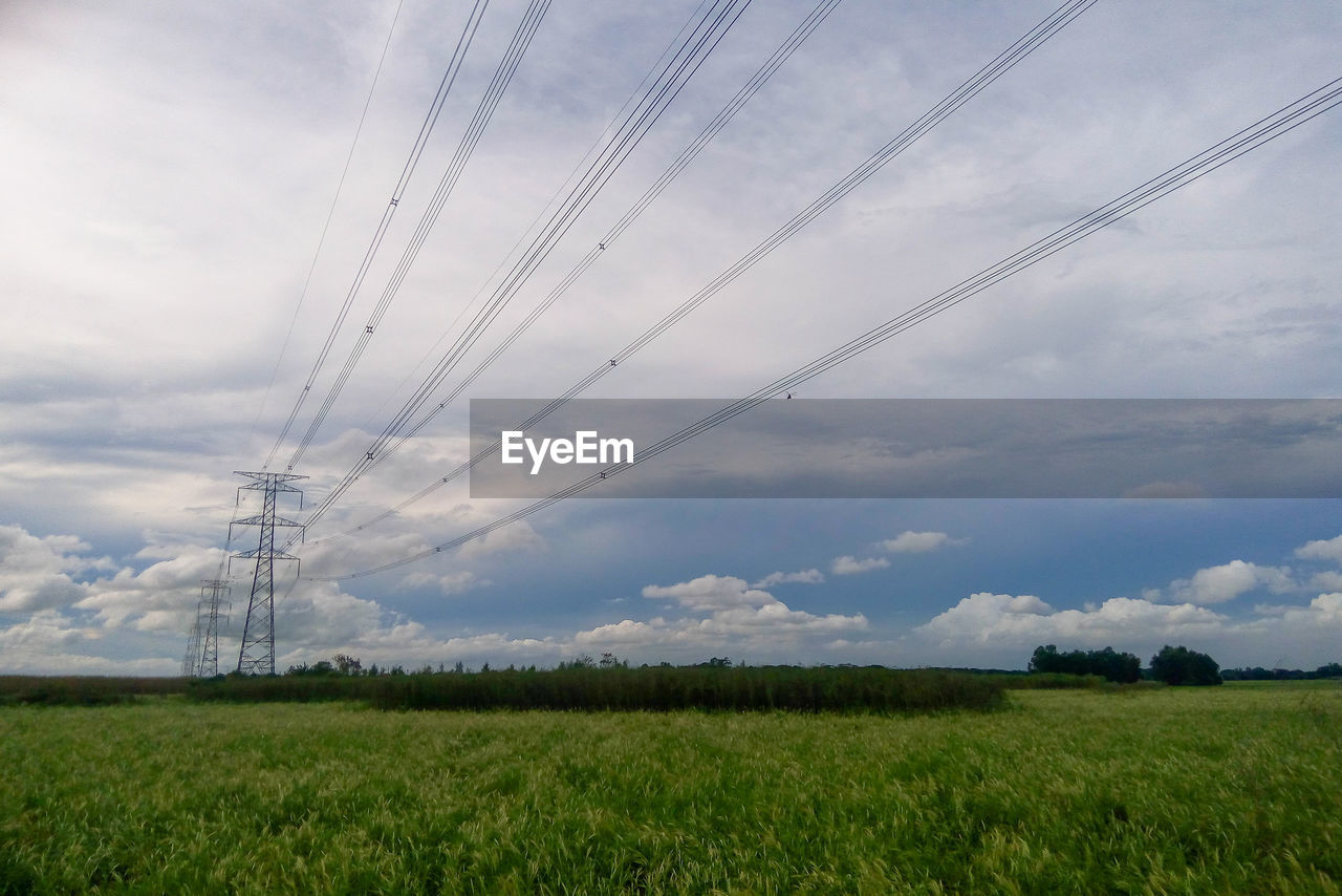 ELECTRICITY PYLON ON FARM AGAINST SKY