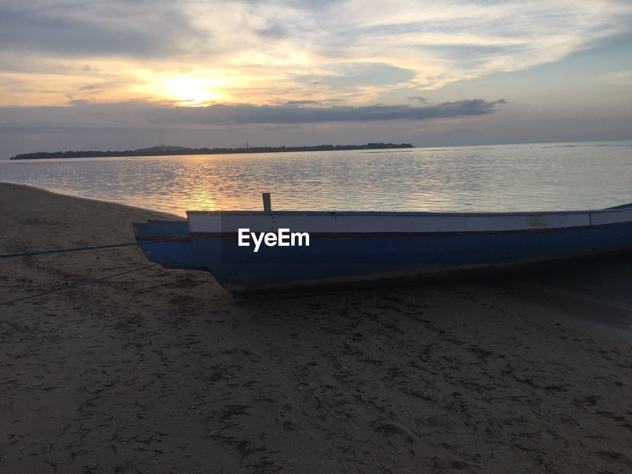 VIEW OF CALM SEA AGAINST CLOUDY SKY DURING SUNSET