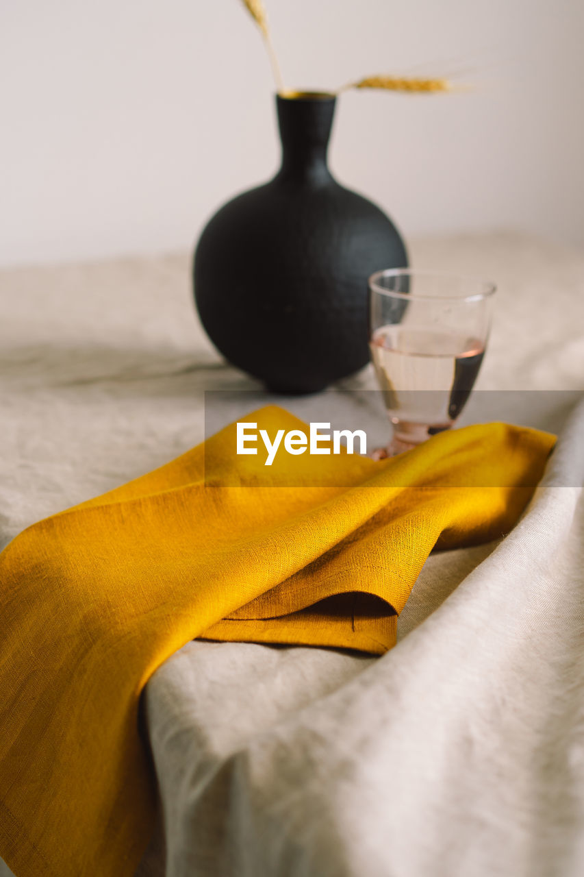 Yellow linen napkin on a tablecloth on a table.