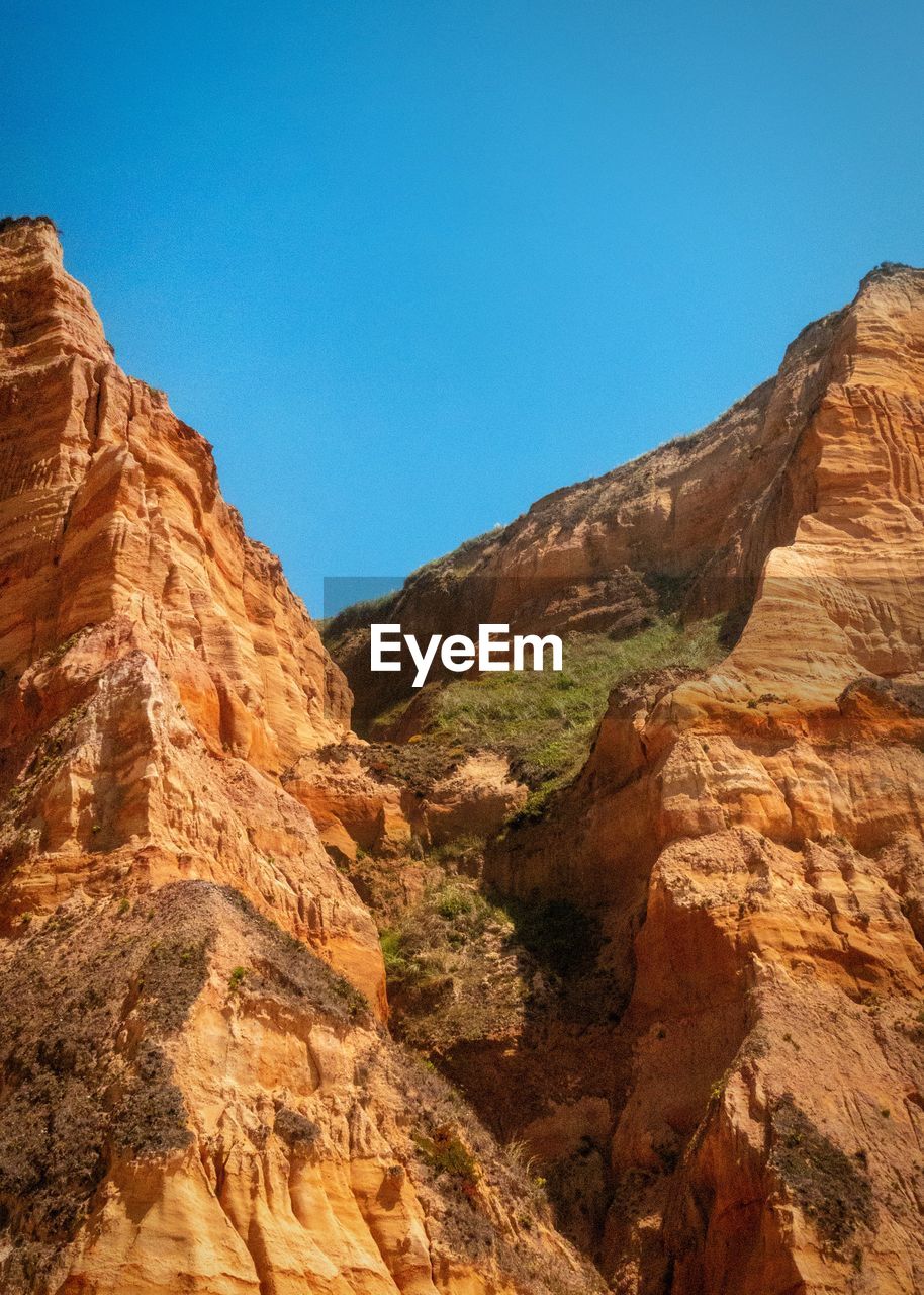 Scenic view of rocky mountains against clear blue sky