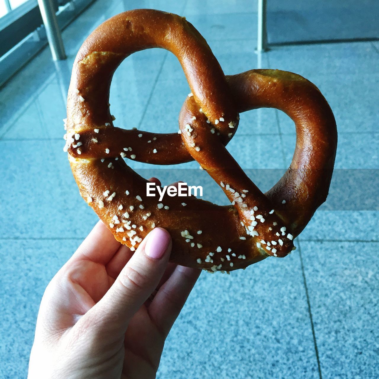 Cropped image of hand holding pretzel