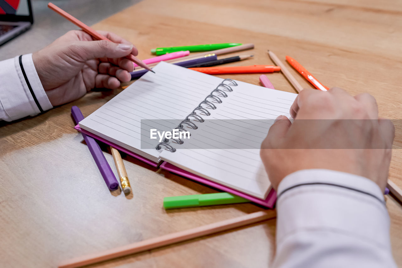 A picture of a business person holding a pen and taking notes in a notebook