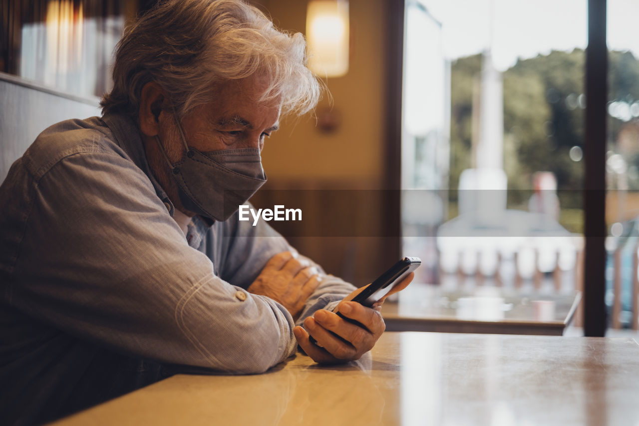 Man using mobile phone while sitting in cafe