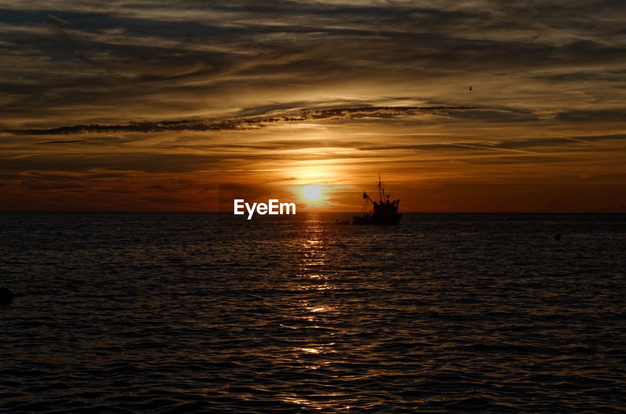 SCENIC VIEW OF SEA AGAINST SKY AT SUNSET