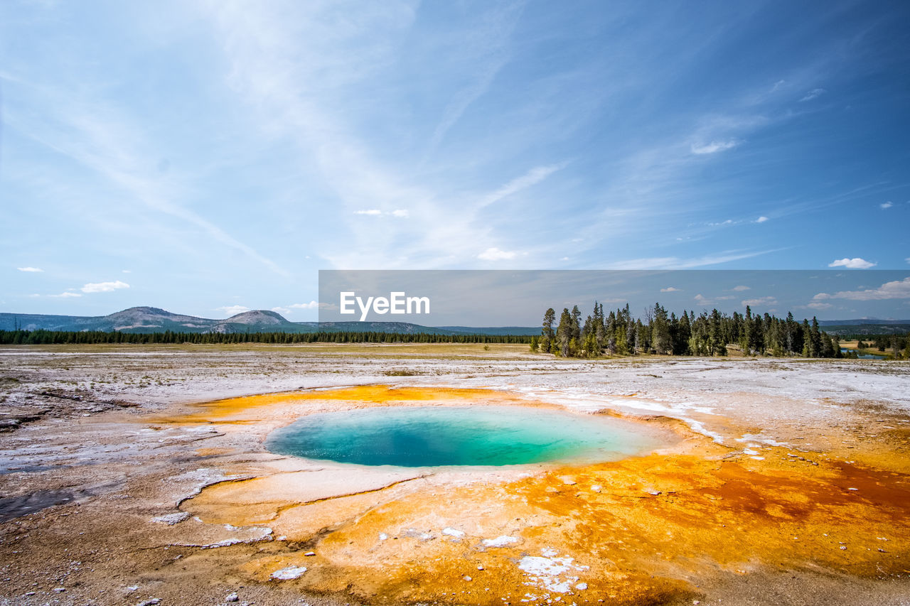 Scenic view of hot spring against blue sky during winter