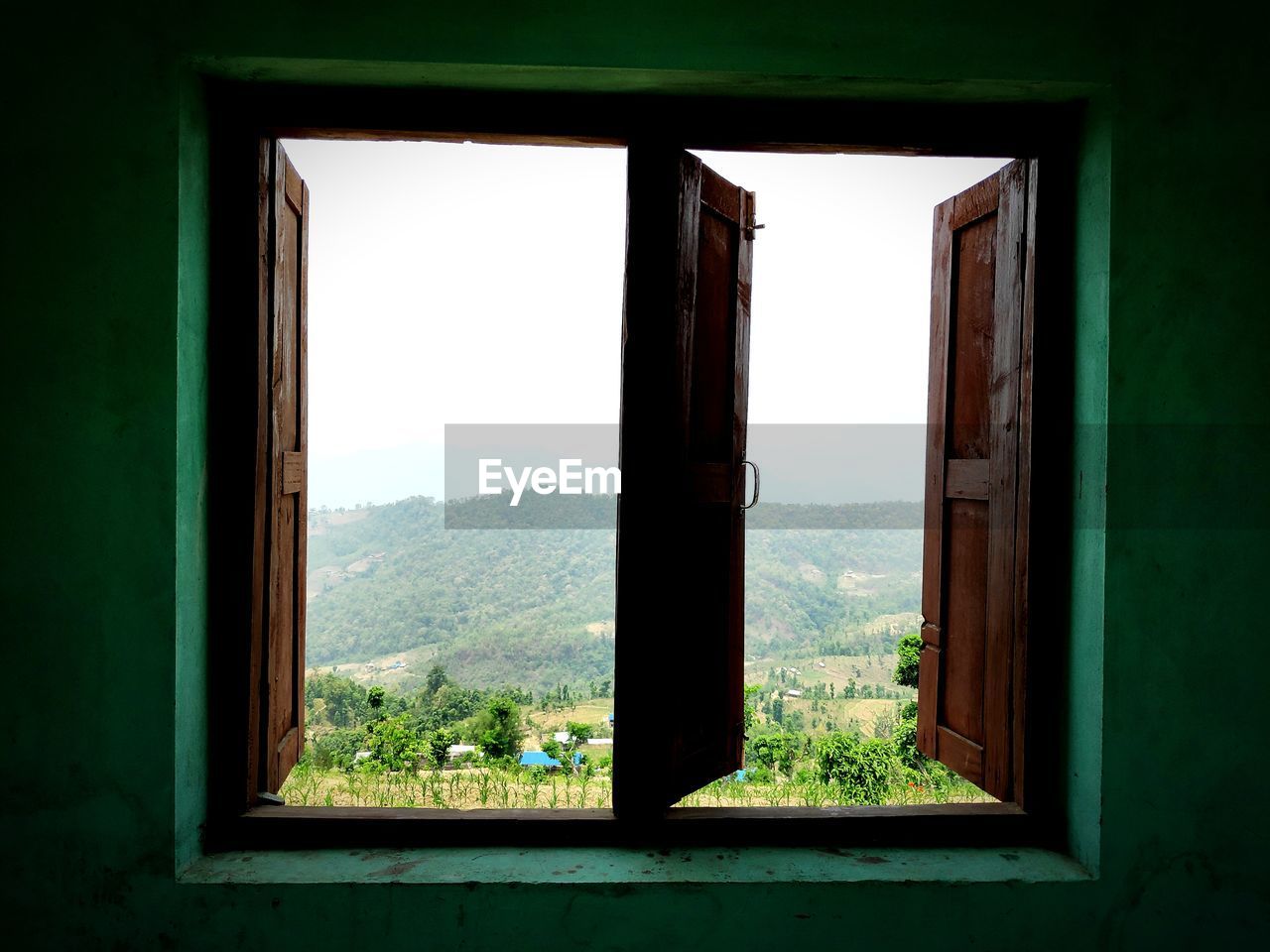 SCENIC VIEW OF MOUNTAINS SEEN THROUGH WINDOW