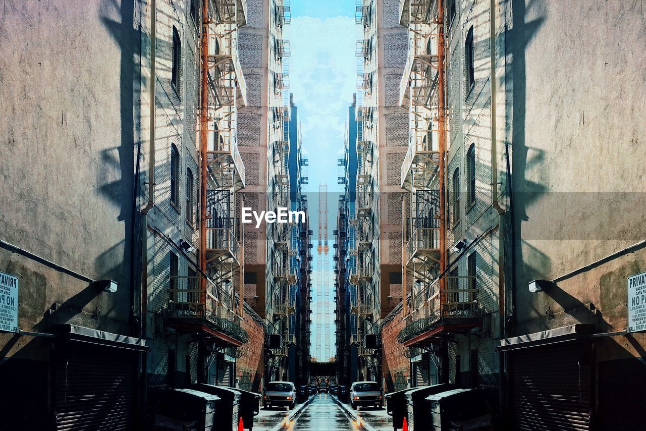 Symmetrical image of street amidst buildings in city