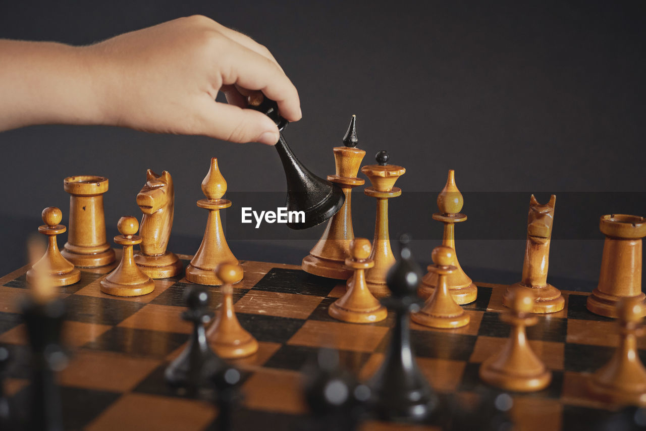 Midsection of person with candles on chess board