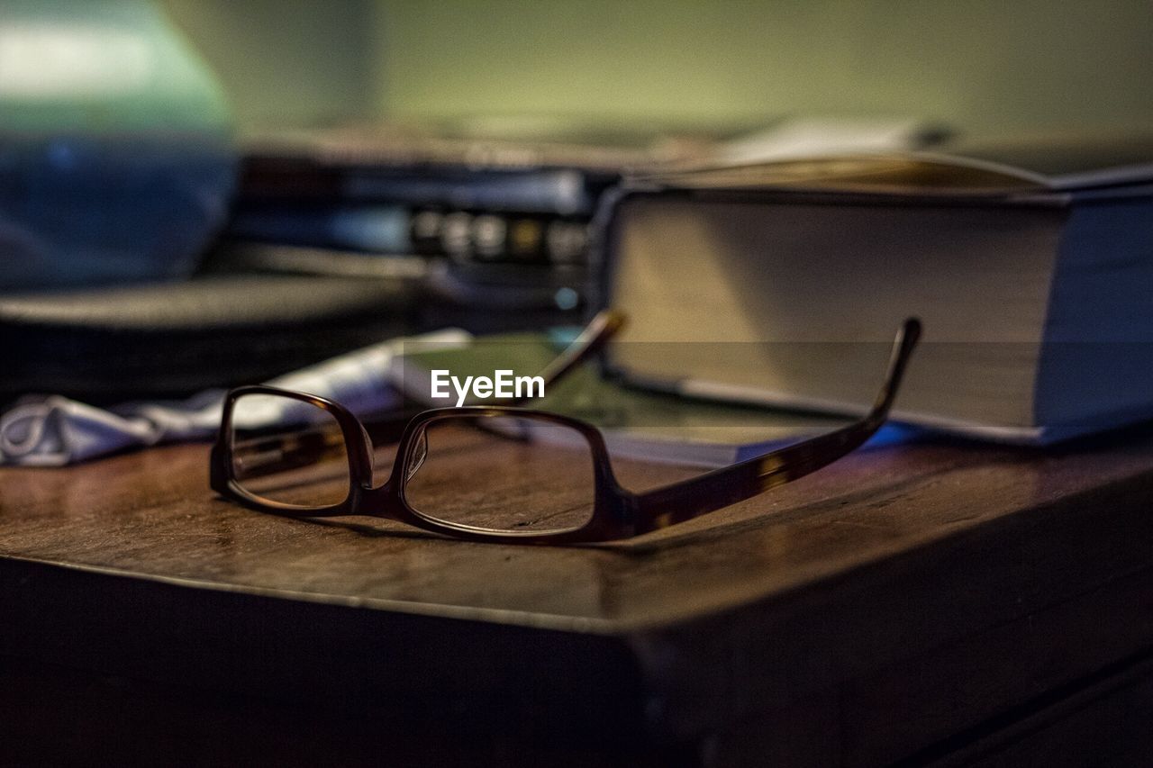 Close-up of eyeglasses by book on table